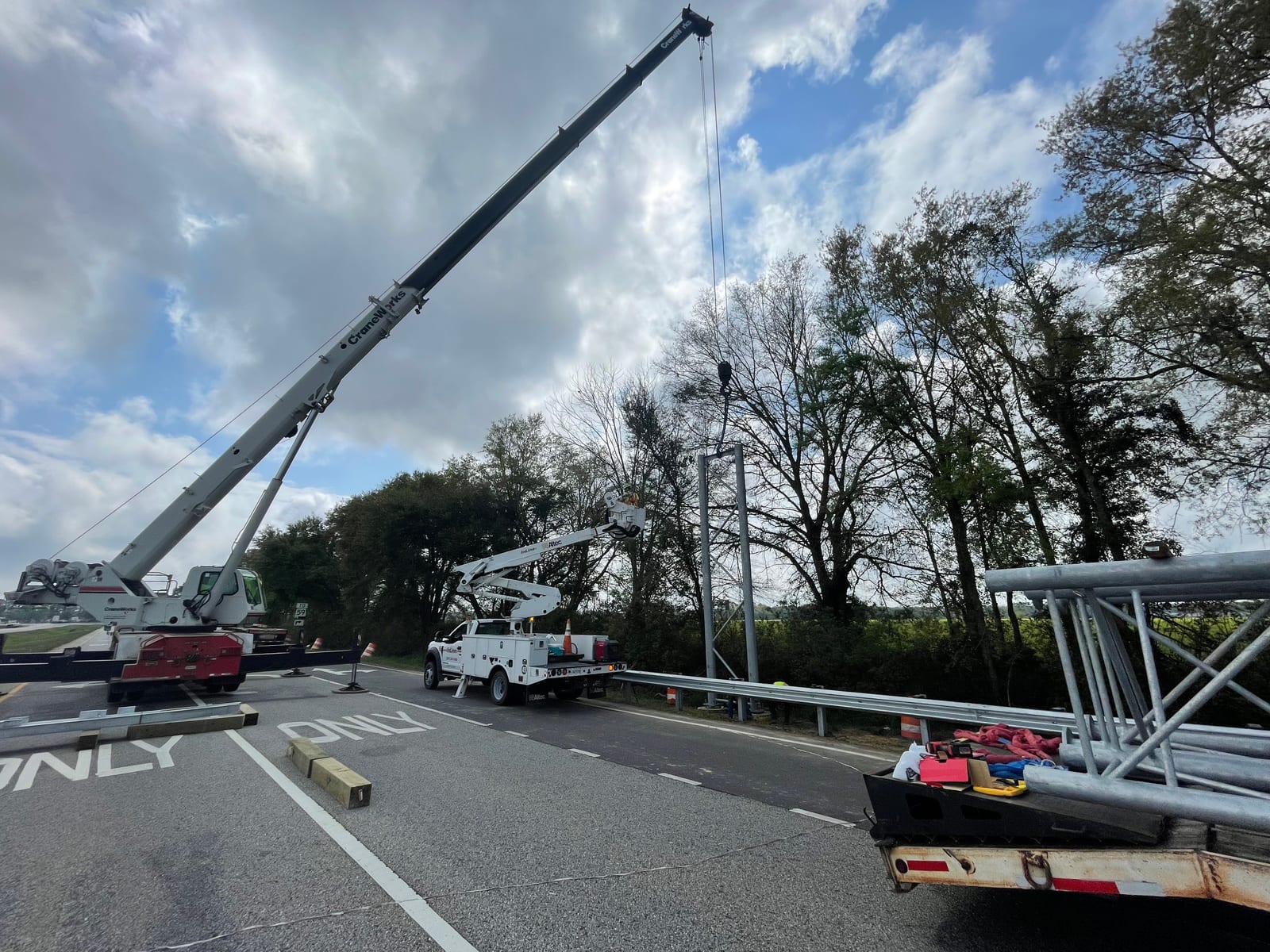 Crane and bucket crews preparing the sign bridge tower and span