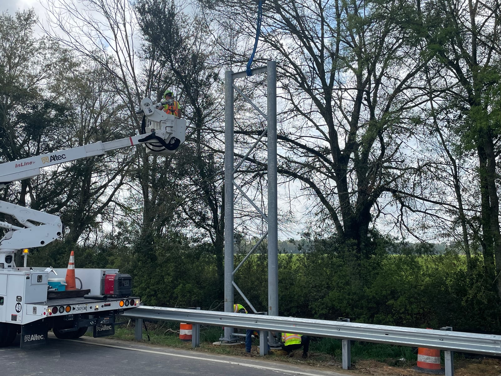 InLine bucket crew completing connections on a galvanized sign bridge tower