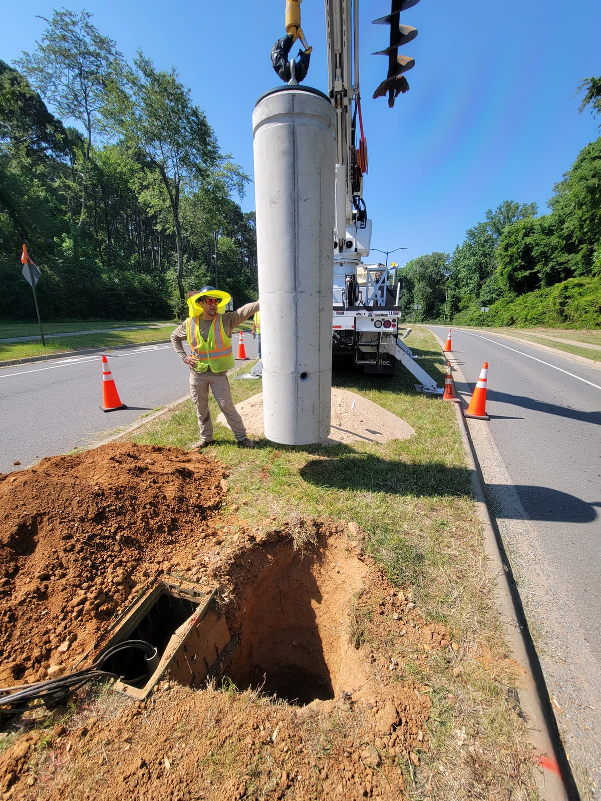 Precast lighting foundation being positioned above the prepared median excavation