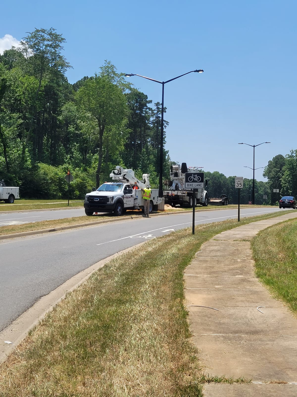 InLine service trucks working beside newly installed double-arm roadway lights