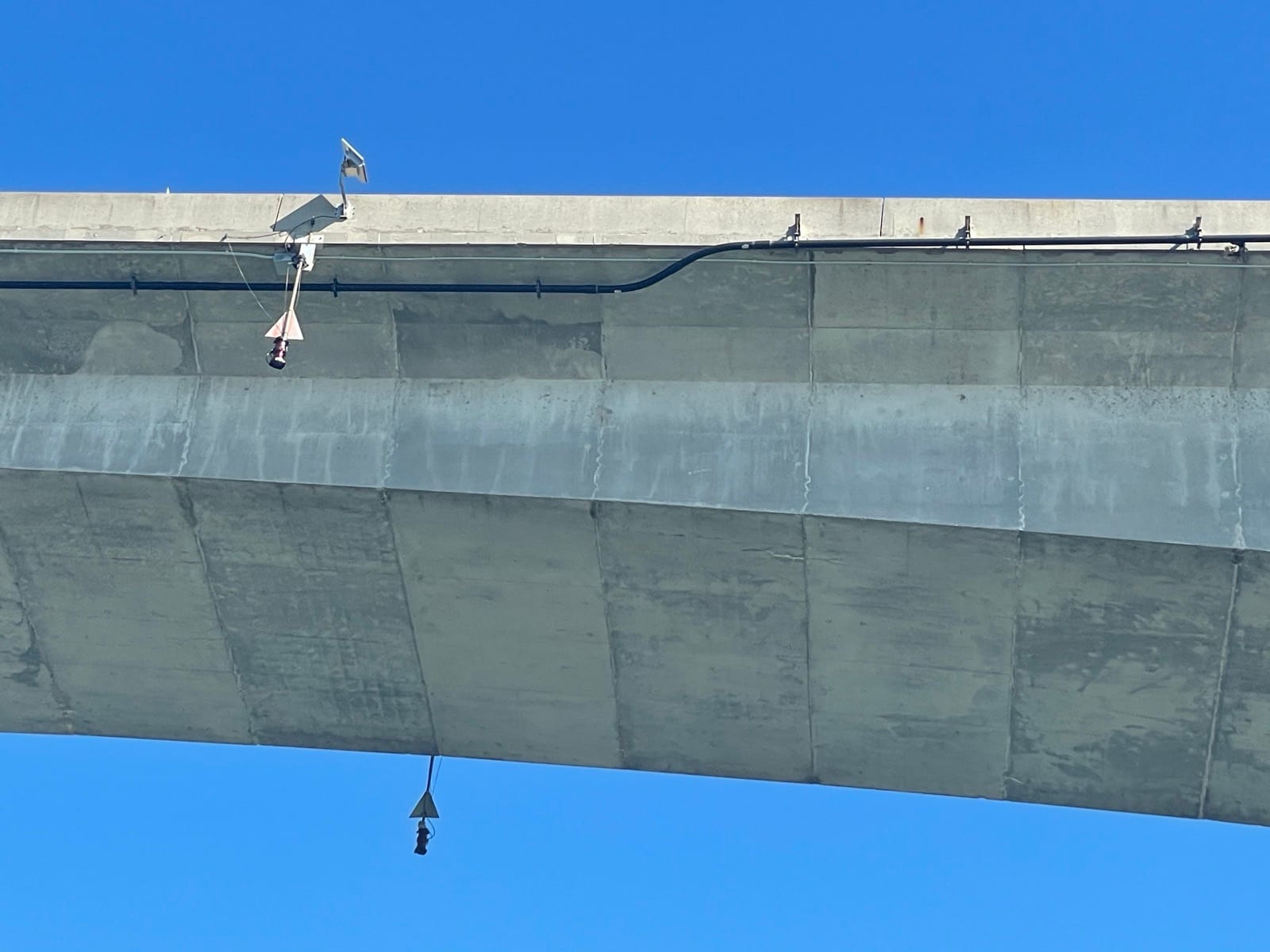Bridge-mounted network equipment and conduit beneath the deck