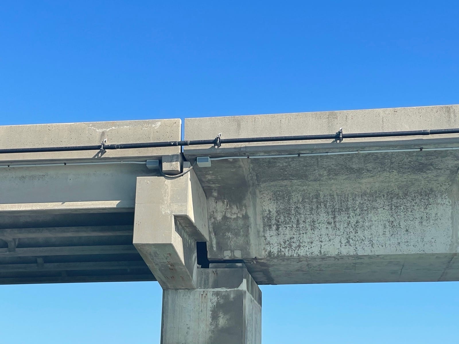 Flexible conduit loop crossing a bridge structure joint