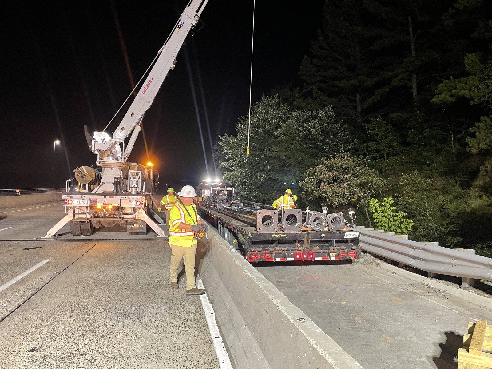InLine crane crew setting an ITS pole during nighttime lane closures