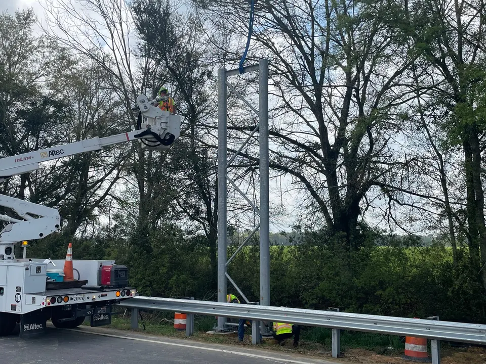 InLine bucket crew completing connections on a galvanized sign bridge tower